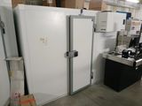 plusieurs réfrigérateurs et congélateurs dans un entrepôt rempli de cartons et encore de cartons