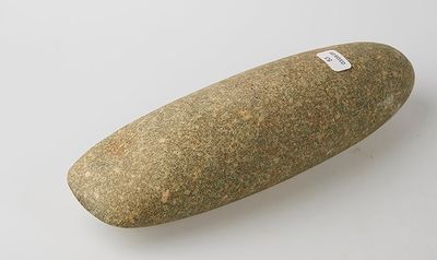 a stone object on a white surface with a sticker on it