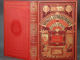 un livre rouge à la couverture richement décorée et orné de lettres dorées