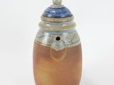 a brown and blue vase with a lid on a white surface