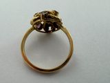 a close up of a gold ring with a flower on top of it