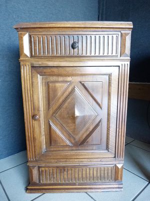 a small wooden cabinet with a door on top of it