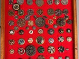 a picture of a display of buttons in a wooden frame