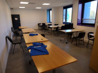 a room with tables and chairs and a blue shirt on the table