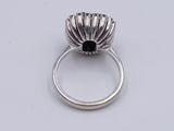 an image of a silver ring with a black stone in the center