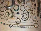 many different types of bracelets and rings laid out on a table