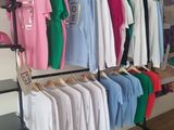many shirts hanging on a rack in a store