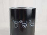 a black cup with a drawing on it sitting on a table