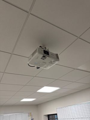 a ceiling mounted projector in the middle of a room