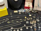 many different necklaces and bracelets displayed on a table