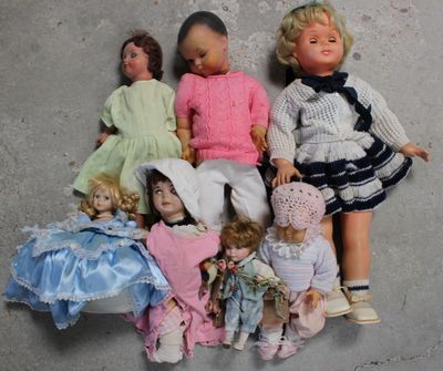 a lot of dolls that are laying on the floor