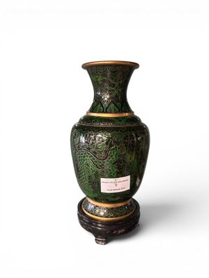 a green vase sitting on a stand on a white surface