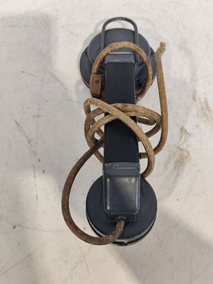 une corde enroulée autour d'un téléphone fixé au mur sur un poteau