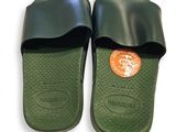 une paire de chaussons verts à semelles en caoutchouc noires sur fond blanc