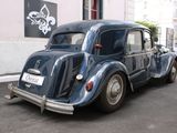 a small blue car parked on the side of the street