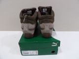 pair of brown shoes sitting on top of a box on a white surface