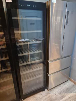 un réfrigérateur et une cave à vin dans un coin de la pièce