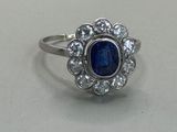 a close up of a blue sapphire and diamond ring on a table