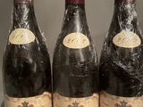 three bottles of wine are wrapped in plastic on a counter