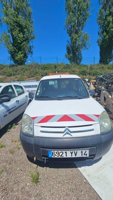 une camionnette blanche garée dans un parking à côté d'autres voitures