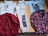several shirts and pants are sitting on a box on the floor