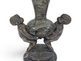 a statue of two people holding a vase on a pedestal