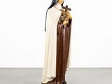 a statue of a nun holding a cross in her hands