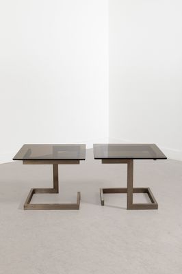 une paire de tables basses noires en verre et métal, avec des pieds carrés