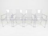 trois chaises en plastique transparent placées les unes à côté des autres sur une surface blanche