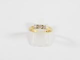 une bague en or jaune surmontée de trois diamants