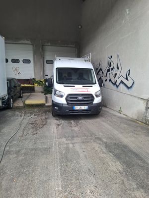une camionnette blanche garée dans un garage dont les murs sont couverts de graffitis