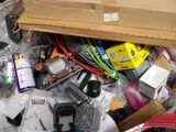 a pile of assorted electronic items in a cardboard box