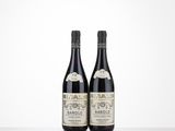 two bottles of wine sitting on top of a table next to each other