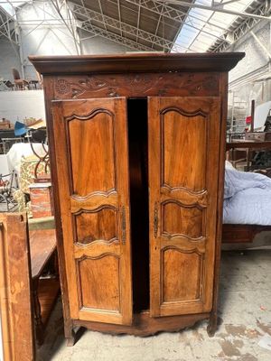 a wooden armoire with two doors open in a room