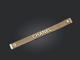 le mot « Chanel » inscrit sur une barre métallique dorée, sur fond noir