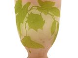 un vase rose orné de feuilles vertes sur fond blanc