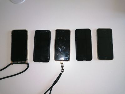 four cell phones are lined up in a row on a table