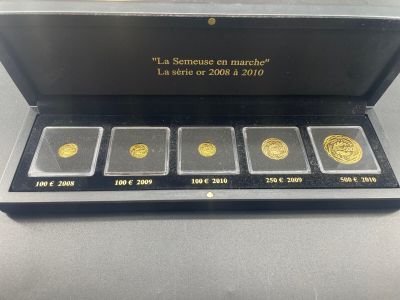 a box of five gold coins sitting on top of a table