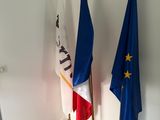 trois drapeaux sont placés les uns à côté des autres dans une pièce