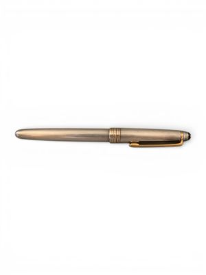 un stylo avec une finition dorée sur fond blanc
