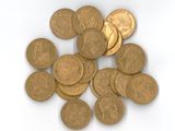 Des pièces d'or sont éparpillées sur une surface blanche, sur fond blanc