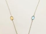 a necklace with multi colored stones on a silver chain