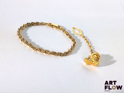 un bracelet en or orné d'une breloque en forme de cœur