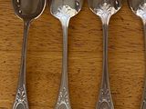 four spoons that are sitting on a wooden table