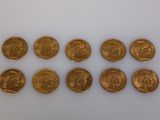 a group of gold coins sitting on top of a white surface