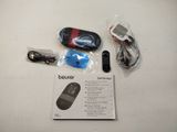 a box with a remote, a mouse, and a cell phone on it