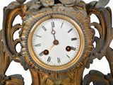 a gold clock with a white face on a stand