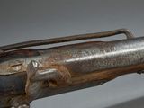 an old gun with a metal handle on a gray background