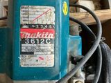a blue machine that is sitting on top of a piece of wood