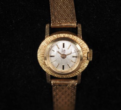 une image représentant une montre-bracelet en or sur fond noir